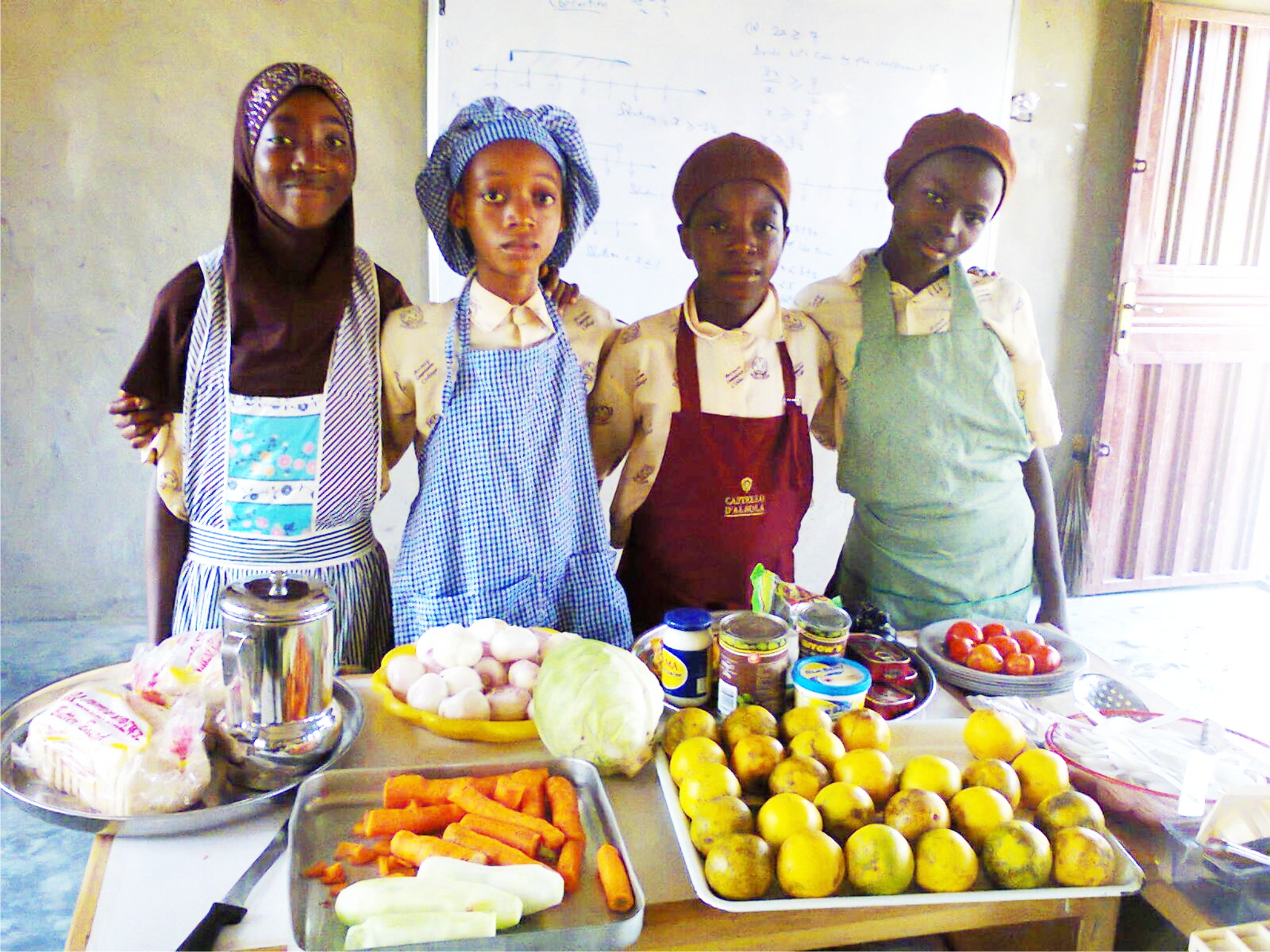 Students presenting ingredients during a practical home economics lesson